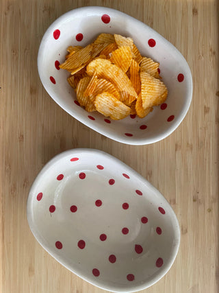 Pair of cute oval ceramic bowls with red polka dots, one filled with chips. Buy artistic ceramics in Bangalore.