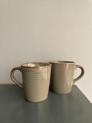 Pair of earthy beige glazed medium-tall ceramic coffee mugs with handles, perfect for your daily brew. Discover handcrafted ceramics Bangalore!